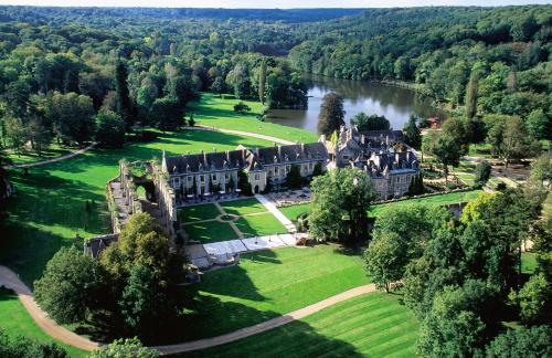 an aerial view of a castle with a river at Abbaye Des Vaux De Cernay in Cernay-la-Ville