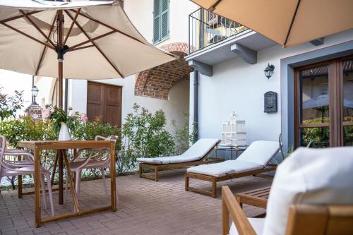 an outdoor patio with chairs and tables and umbrellas at La Lupa La Morra in La Morra