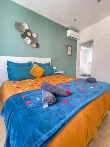 Una cama con una manta azul y naranja. en Le bourget - Suite romantique, en Narbona