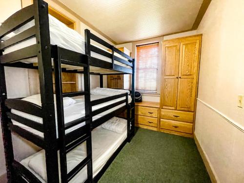 a bunk bed room with three bunk beds in it at Charming School House with Large Pool in Huron