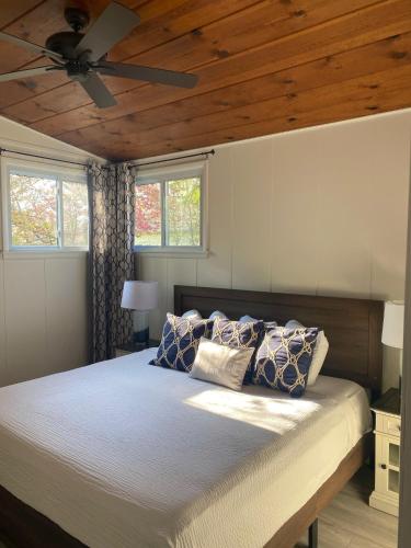 a bedroom with a bed with a ceiling fan at Newly Renovated! Old Homestead Beach Home in Huron