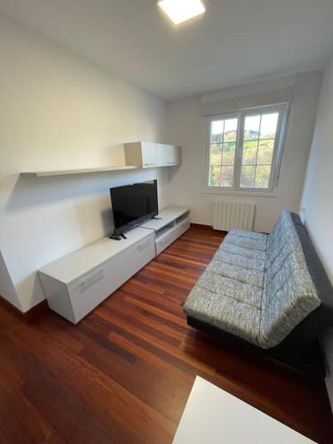 a living room with a couch and a flat screen tv at Amplio piso Duplex en Elorrio. in Elorrio