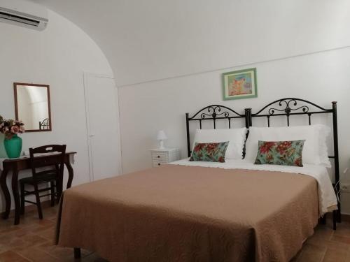 um quarto com uma cama e uma mesa com uma cadeira em Le Stanze dell'Emiro em Sambuca di Sicilia