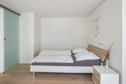 a white bedroom with a bed with white sheets and pillows at Ferienwohnung Feine Natur in Bahlingen