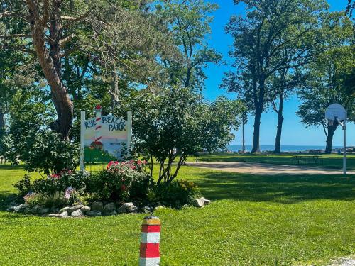 a park sign in the grass with a sign for a fish park at Rye Beach Family Cottage in Huron