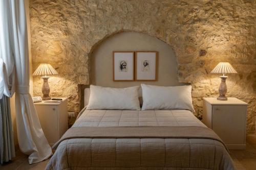 ein Schlafzimmer mit einem Bett in einer Steinmauer in der Unterkunft Castello Camemi in Vizzini