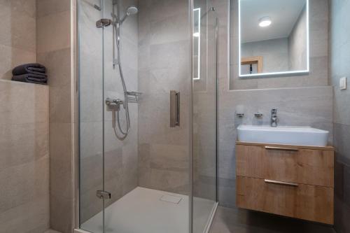 y baño con ducha y lavamanos. en TALBERG SK - Garage parking - Quiet place - Brand new apartments - Tále, en Tale