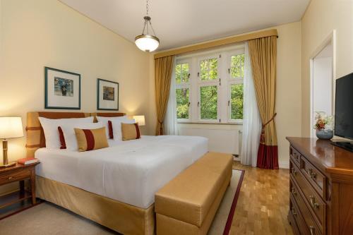 a bedroom with a large white bed and a window at Falkenstein Grand, Autograph Collection in Königstein im Taunus