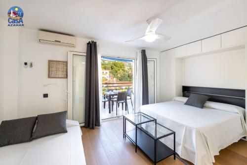a bedroom with a bed and a balcony with a table at Apartamentos Fuente Sol Casa Azahar in Alcossebre
