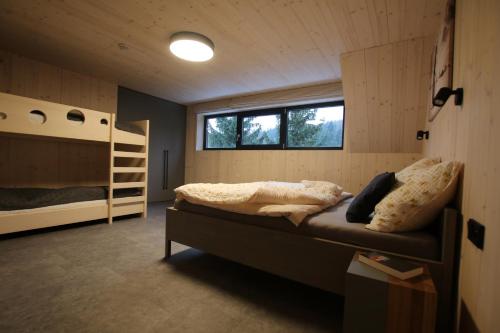 a bedroom with a bed and bunk beds in it at Chata Jestřábník in Dolní Morava