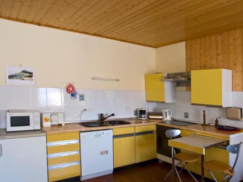 a kitchen with yellow and white cabinets and a table at Freyja in Beerfelden