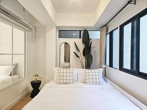 a bedroom with a bed with white sheets and pillows at PB home 1 min to BTS Saladaeng & MRT Silom in Bang Rak