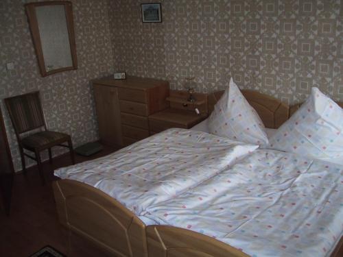 niepościelone łóżko w sypialni z krzesłem w obiekcie Freyja w mieście Beerfelden
