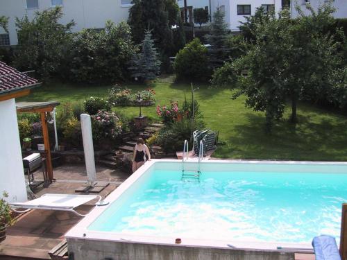 a woman is standing next to a swimming pool at Freyja in Beerfelden