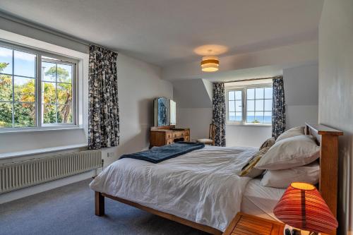 um quarto com uma cama e duas janelas em Finest Retreats - Tregatreath em Coverack