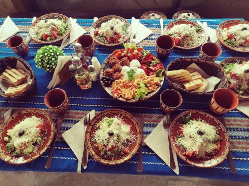 a blue table with plates of food on it at Хотел механа Караджейката 
