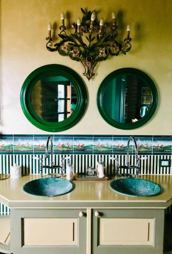 two sinks in a bathroom with two mirrors at B&B Tenuta il Galletto in Casale Monferrato