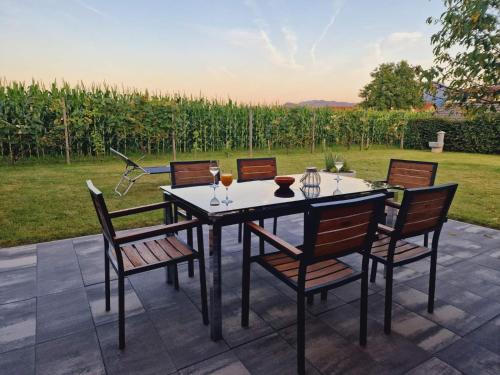 una mesa y sillas con copas de vino en el patio en Orange house Šempeter, en Šempeter v Savinjski Dolini