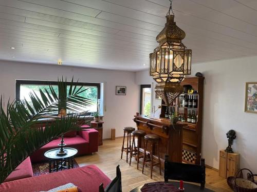ein Wohnzimmer mit einer Bar und einem Kronleuchter in der Unterkunft Urlaubstraum am Brombachsee- 5 stilvolle Zimmer- in Pleinfeld