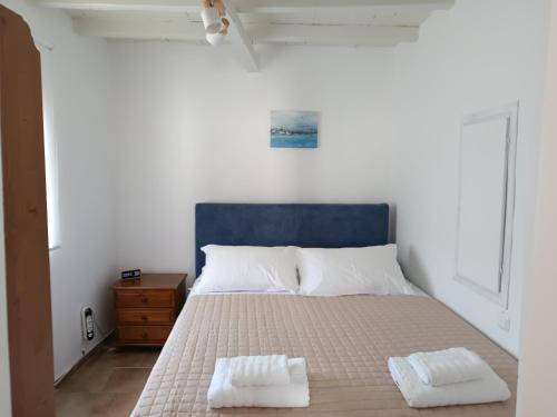 a bedroom with a bed with two towels on it at Perseids Traditional House in Amorgos