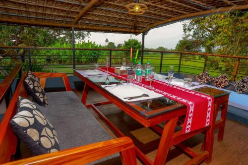 Una mesa de comedor y sillas en una terraza con vista. en Premium Houseboat, en Alleppey