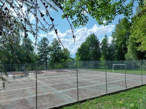 una pista de tenis con una red y un banco en ella en Ciel Bleu - Cir 0122, en Pila