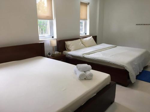 a teddy bear sitting on two beds in a room at Maykenn Beach in Bantayan Island