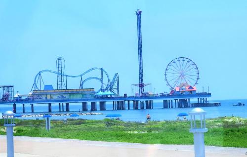 a pier with a roller coaster and a ferris wheel at CasaAzul-2605A-Couples Retreat By Pleasure Pier, Beach, Seawall,a block away 5 Minutes from Strands and Cruise Terminal in Galveston