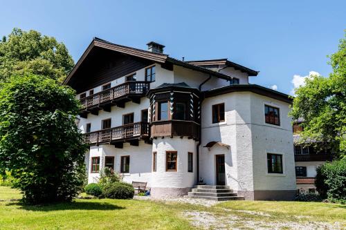 uma grande casa branca com um telhado preto em City Center Rooms Kitzbühel em Kitzbühel