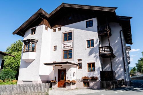 a white house with a black roof at City Center Rooms Kitzbühel in Kitzbühel