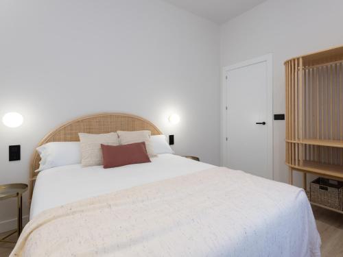 a bedroom with a large bed with white sheets at Meraki Suites in Astorga