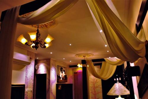 a living room with curtains and a chandelier at Boutique Studio- Riverine Diamond in Kuching