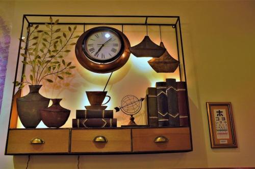 a shelf with vases and a clock on a wall at Boutique Studio- Riverine Diamond in Kuching