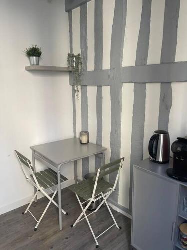 une table et des chaises dans une pièce avec un mur dans l'établissement Studio au cœur de Rouen, à Rouen