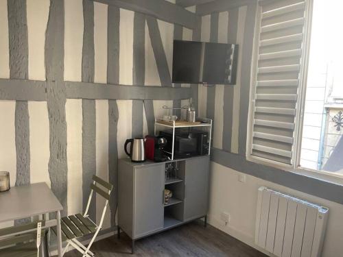 a living room with a tv on a striped wall at Studio au cœur de Rouen in Rouen