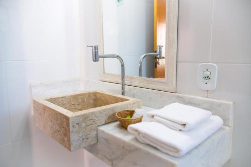 uma casa de banho com um lavatório de pedra e um espelho. em Dunas de Itaipu em Niterói