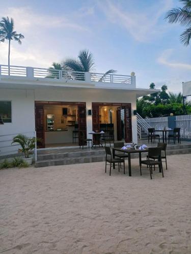 a house with chairs and a table in front of it at Maykenn Beach in Bantayan Island