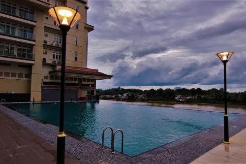 a swimming pool with two lights next to a building at Boutique Studio- Riverine Diamond in Kuching