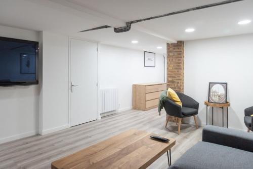 un salon avec un canapé et une télévision dans l'établissement Spacious and comfortable apartment in Paris 17th, à Paris