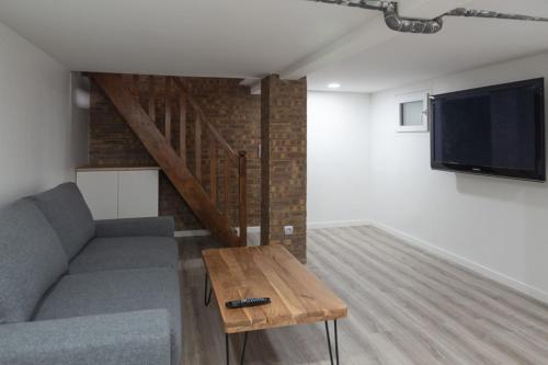 un salon avec un canapé et une télévision à écran plat dans l'établissement Spacious and comfortable apartment in Paris 17th, à Paris
