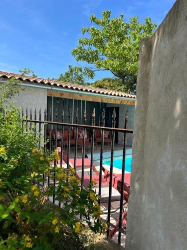 a fence in front of a house with a swimming pool at Le240b #5 in Saint-Mard