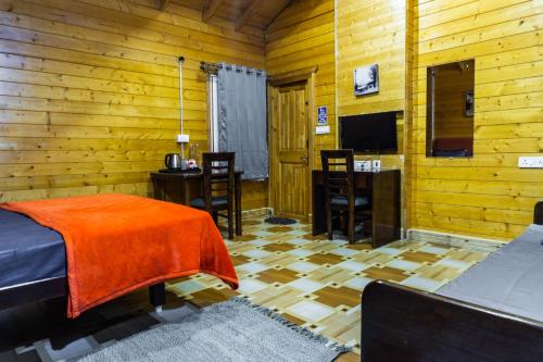 um quarto com uma cama e uma televisão num quarto em The Door to Nirvana Cottages em Coonoor