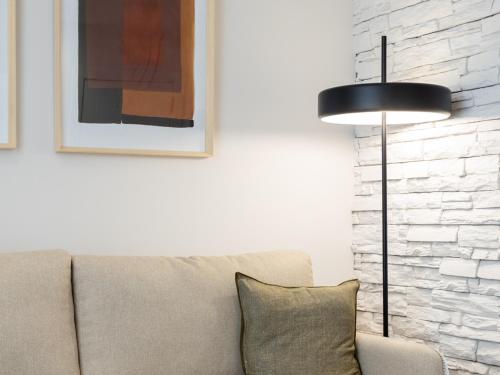 a living room with a couch and a lamp at Meraki Suites in Astorga