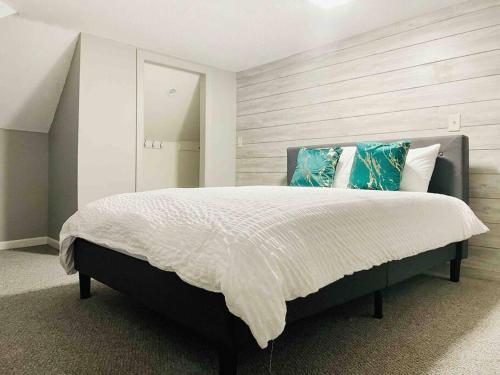 a bedroom with a large bed with blue pillows at Leaning House of Haynie in Evansville