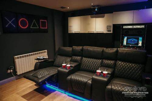 a living room with leather furniture and a video game at Princes st by Prestige Properties SA in Ulverston