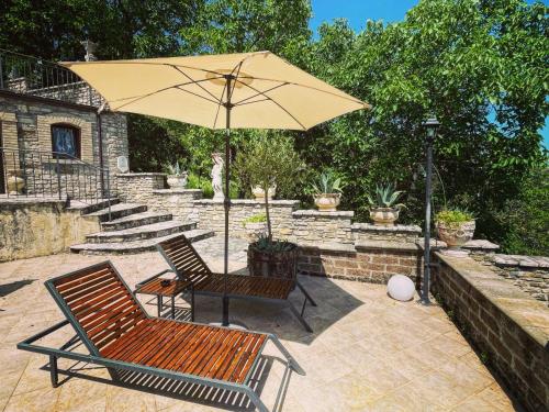 a patio with two chairs and an umbrella at L'Antica Dimora in Macchiagodena