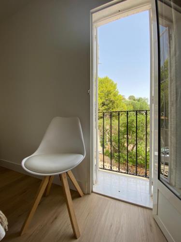 una silla blanca sentada frente a una ventana en Apartamento PLAYA LAS VENTANICAS en Mojácar