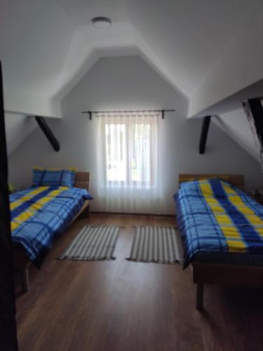 a attic room with two beds and a window at Kuća za odmor Obitelj Kušan in Veliki Erjavec