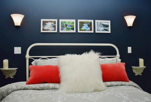 Un dormitorio con una cama con almohadas rojas y blancas. en Luxury Cottage at Millpond Falls, en Warwick