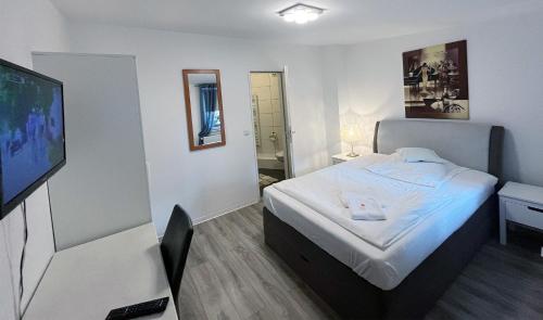 um quarto de hotel com uma cama e uma televisão de ecrã plano em Restaurant Donau em Hanôver